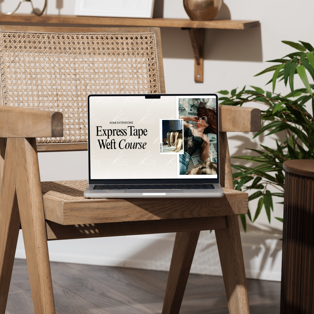 Laptop on a wooden chair displaying a course title with a plant in the background