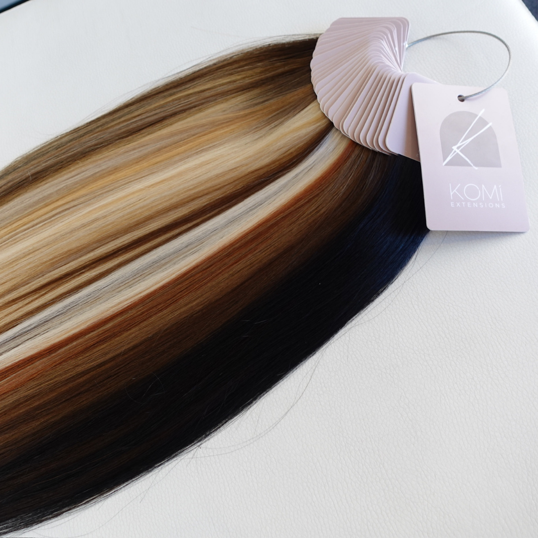 Komi Extensions Color Ring sample displaying multiple shades of premium tape-in extension hair swatches
