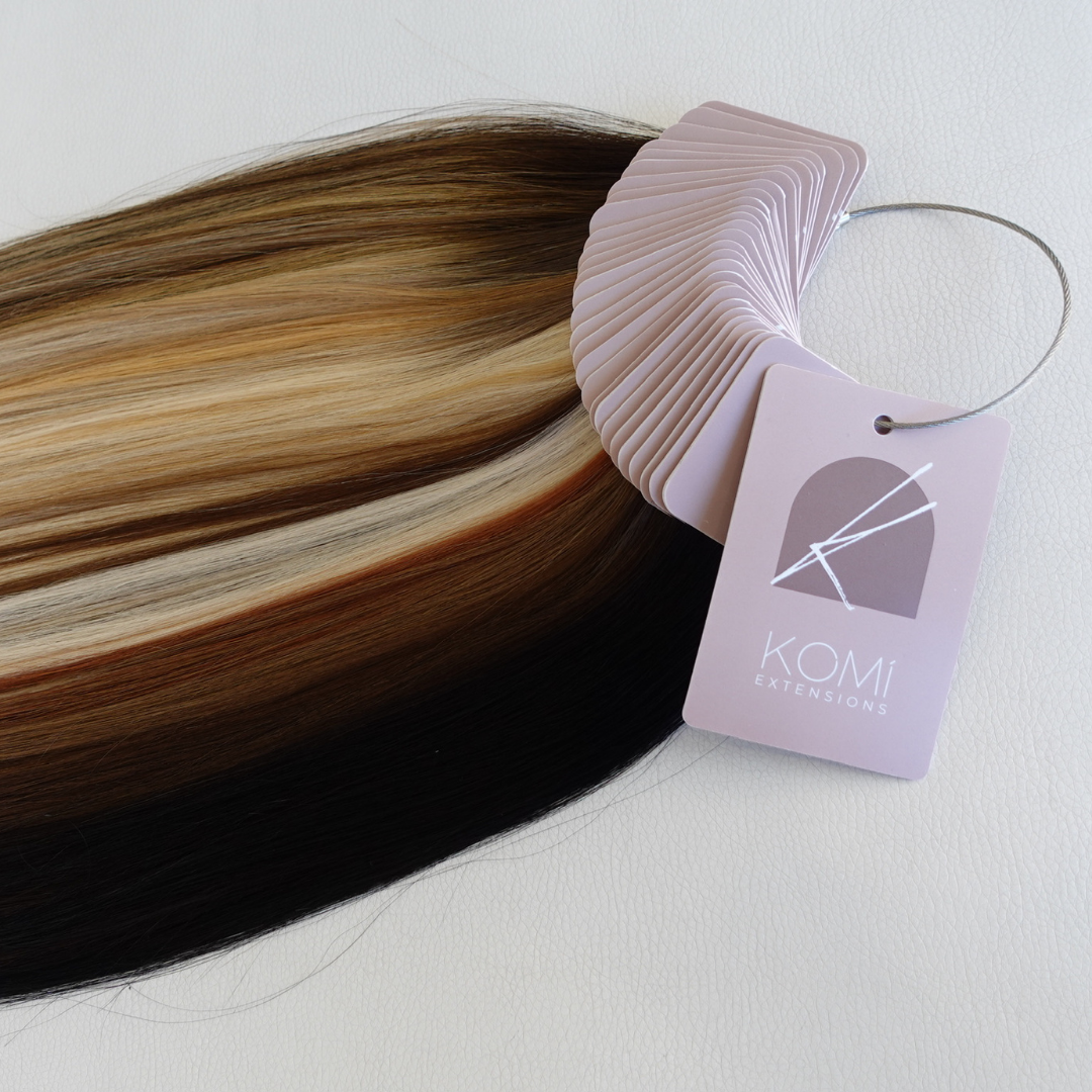 Komi Extensions Color Ring sample displaying premium tape-in hair swatches in multiple natural shades